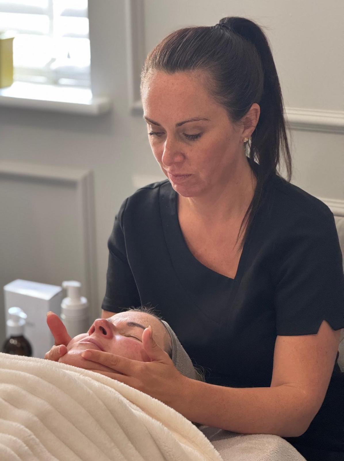 Claire performing a facial treatment at Skin Lux